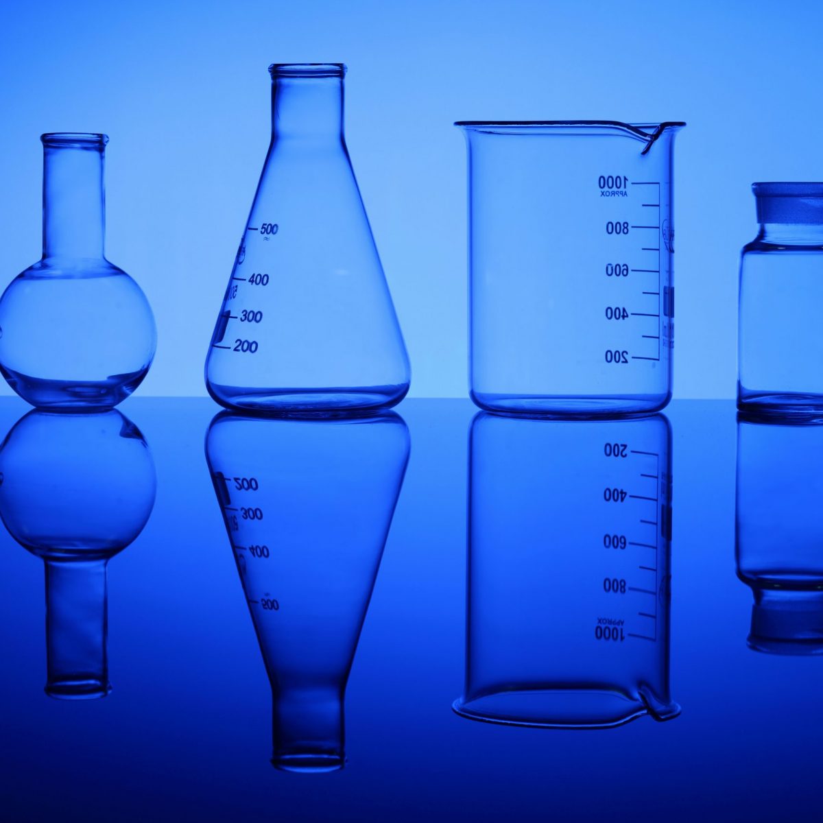 Glass chemistry tubes on a colour background