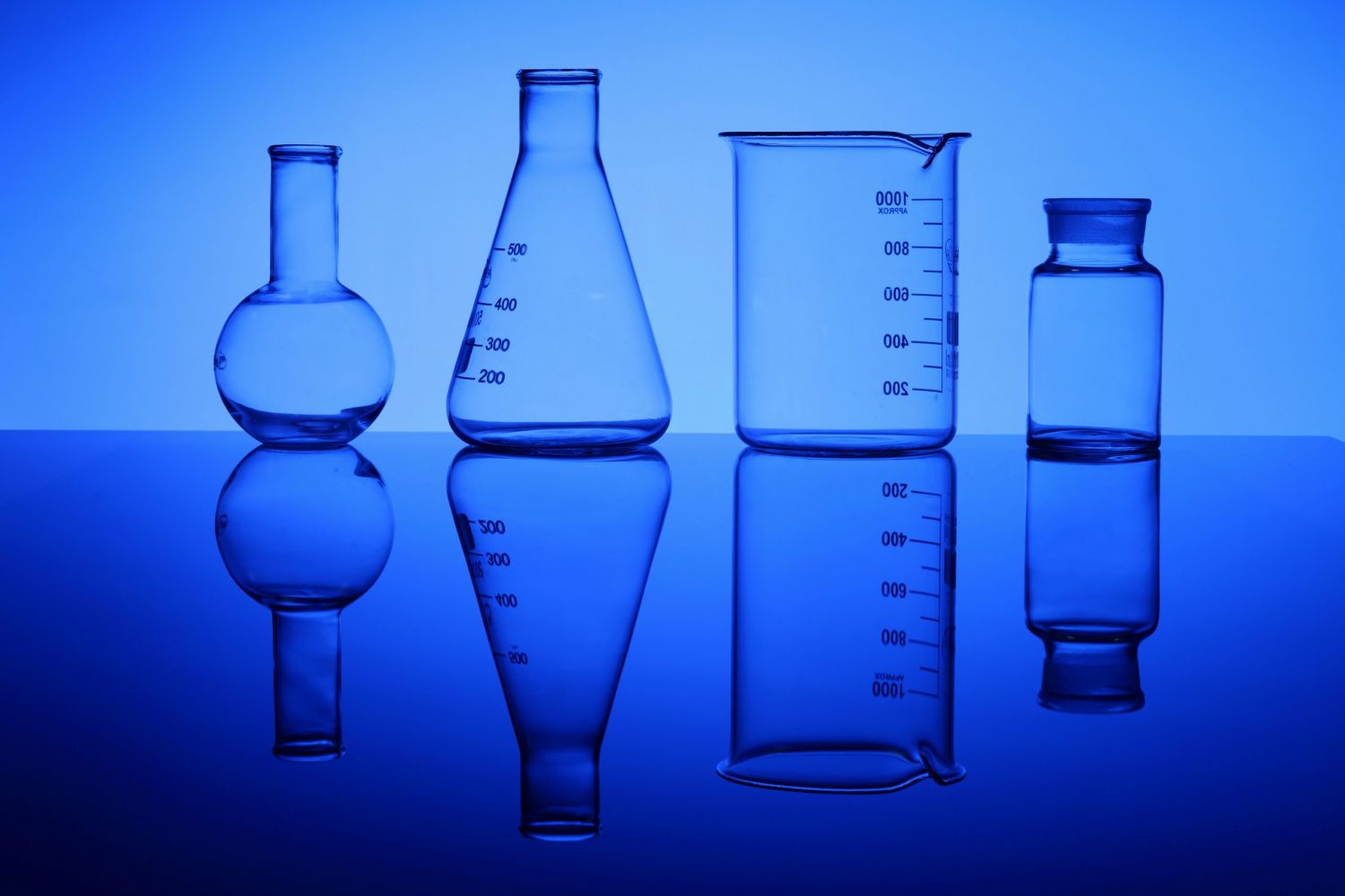 Glass chemistry tubes on a colour background